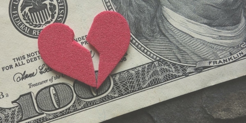 Image of a one-hundred dollar bill with a red broken heart laying on top of it.