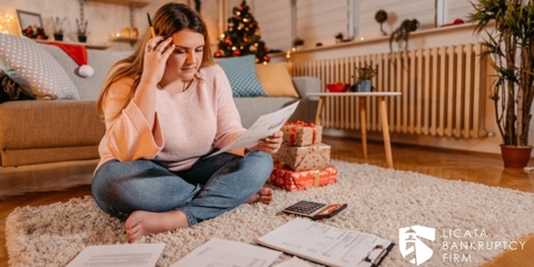 woman looking at documents and Christmas presents while feeling stressed