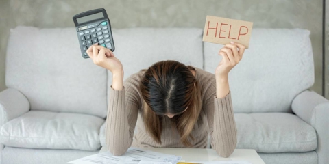 Stressed woman with large bills or invoices