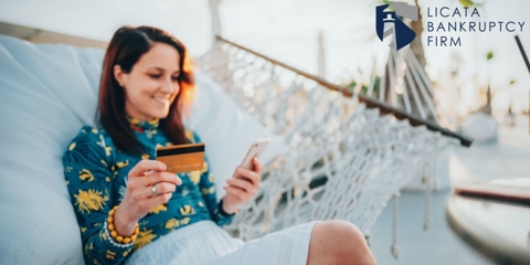 woman looking at credit card on vacation