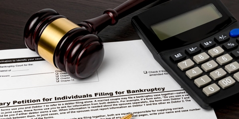 Pen, gavel, and calculator on bankruptcy form