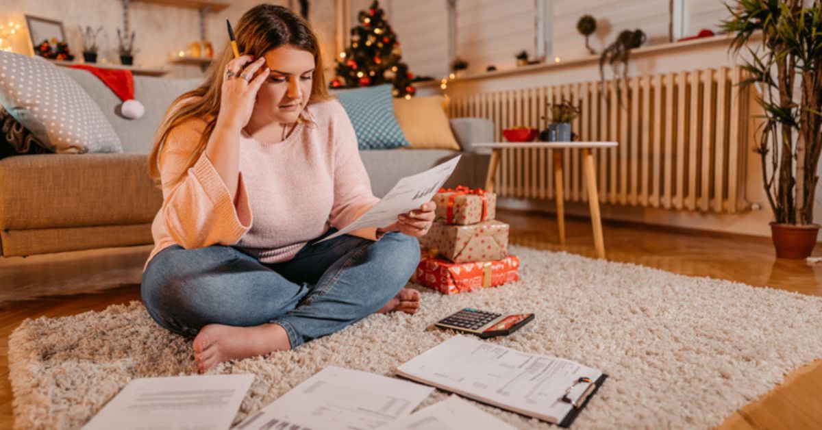 woman looking at documents and Christmas presents while feeling stressed